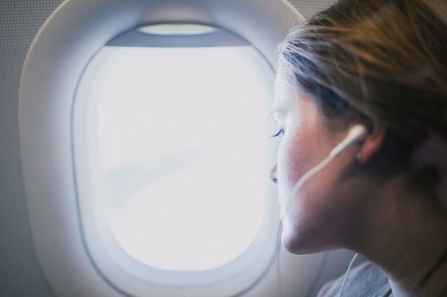 woman on aeroplane looking out of window