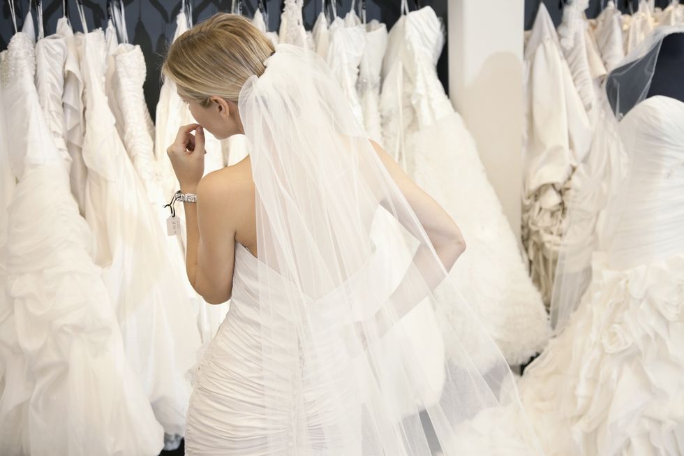 woman trying on wedding dresses in bridal boutique