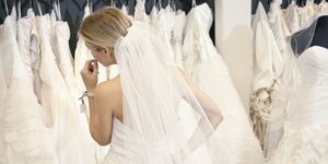 woman trying on wedding dresses in bridal boutique