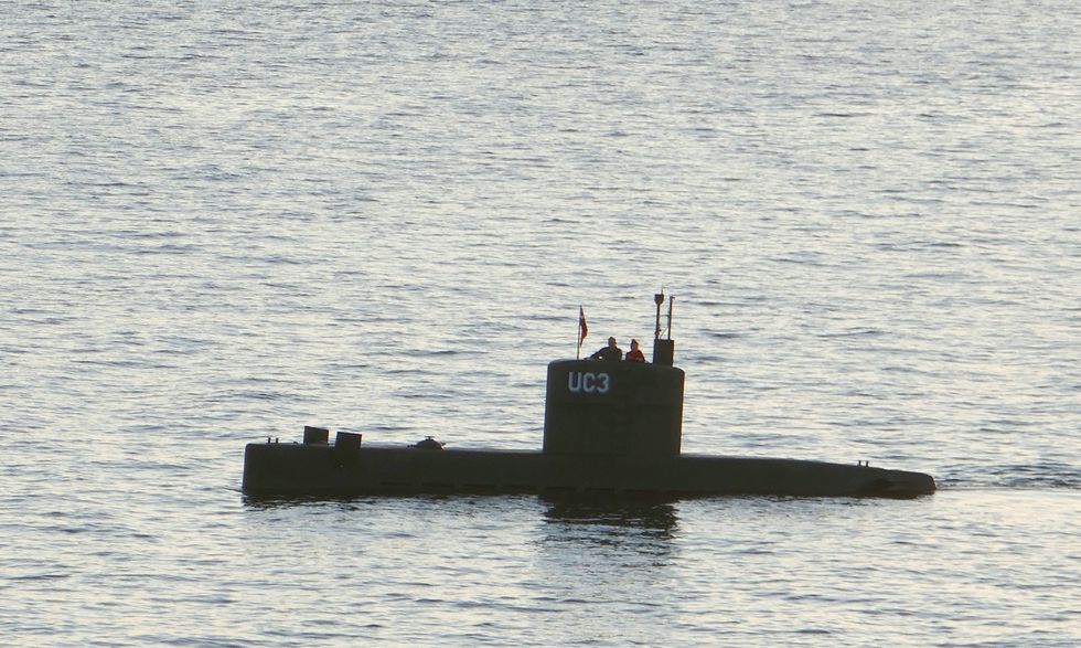 Swedish journalist Kim Wall stands next to a man in the tower of the private submarine 'UC3 Nautilus' on August 10, 2017 in Copenhagen Harbor | ELLE UK