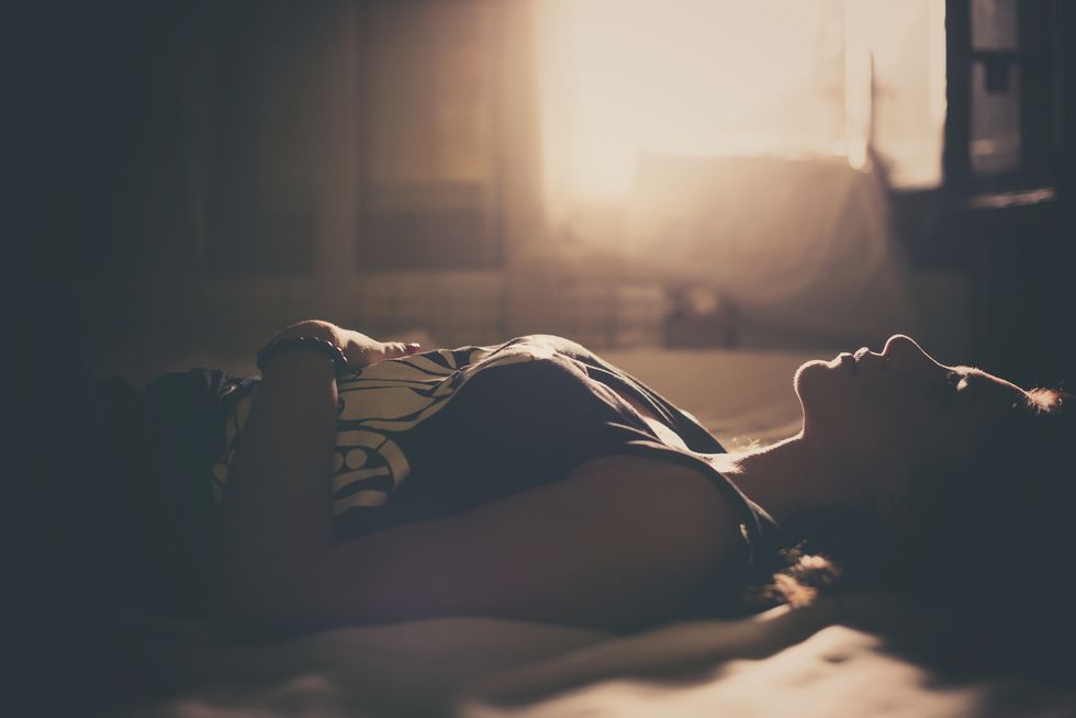 Sad girl in bed, backlit scene | ELLE UK