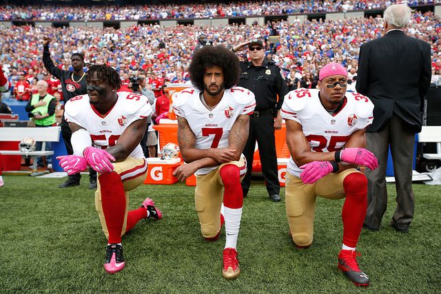 Colin Kaepernick #7 and Eric Reid #35 of the San Francisco 49ers kneel in protest on the sideline, during the anthem, prior to the game against the Buffalo Bills at New Era Field on October 16, 2016 in Orchard Park, New York | ELLE UK