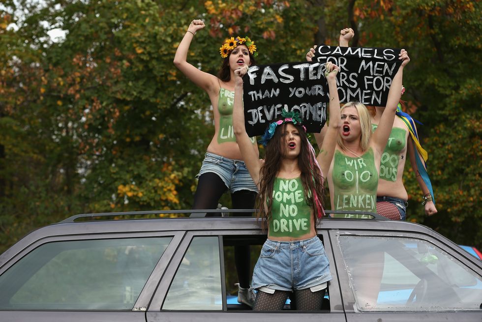 Activists from the women's rights-group Femen bare their breasts while protesting outside the Saudi embassy against the prohibition on women driving in Saudi Arabia on October 28, 2013 in Berlin, Germany | ELLE UK