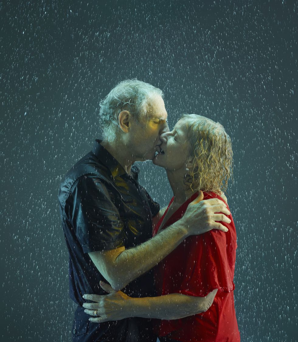 senior couple kissing - old couple in the rain