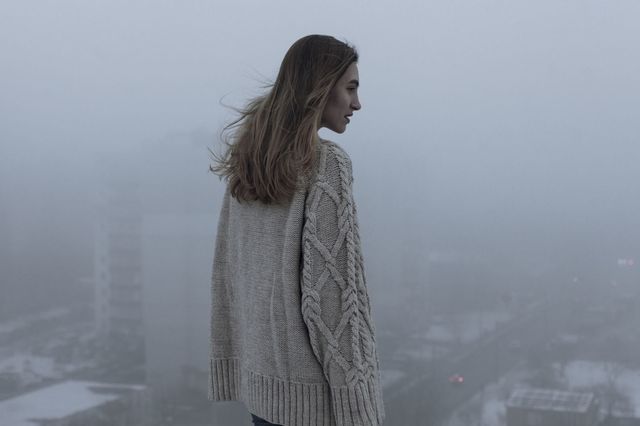 woman standing top of building smog