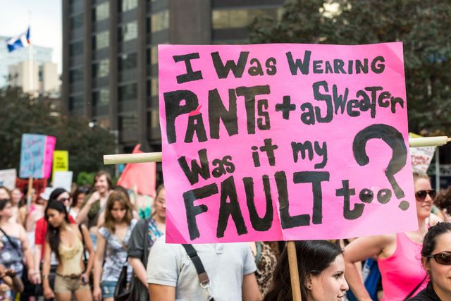 A protest sign reading ''I was wearing pants + a sweater, was it my fault too'' Taken during ''Slut Walk 2012'', a protest event about sexual assault and victims' rights | ELLE UK