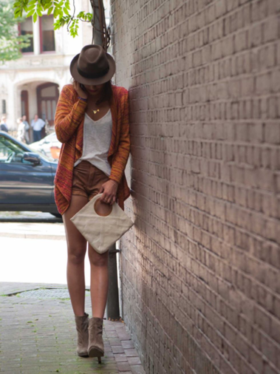 Brown, Hat, Textile, Human leg, Brick, Outerwear, Dress, Fashion accessory, Street fashion, Sun hat, 