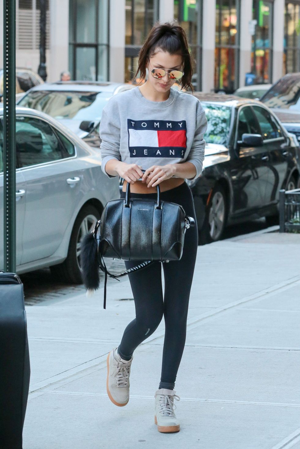 <p>Bella Hadid houdt het casual in een legging met <em data-redactor-tag="em" data-verified="redactor">cropped </em>Tommy Jeans-sweatshirt, pilotenbril, een&nbsp;Givenchy-tas en hoge sneakers.&nbsp;</p>