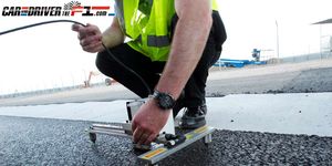 Asphalt, Road surface, Elbow, Wrist, Machine, Tar, Bracelet, Rolling, Tool, High-visibility clothing, 