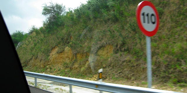 Vegetation, Road, Slope, Sign, Traffic sign, Signage, Guard rail, Street sign, Terrain, Hill station, 