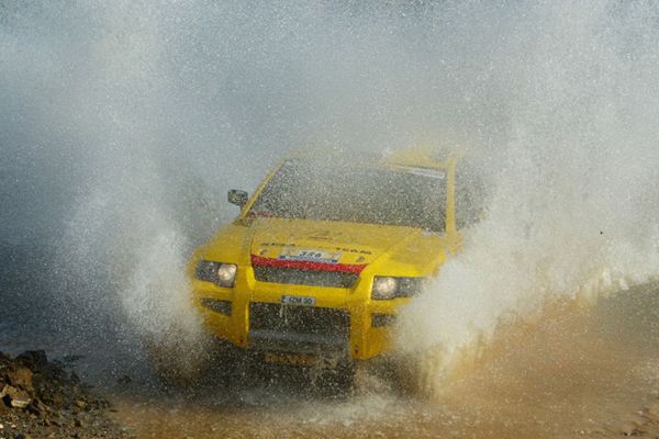 Automotive design, Yellow, Land vehicle, Hood, Off-roading, Dust, Atmospheric phenomenon, Off-road vehicle, Bumper, Off-road racing, 