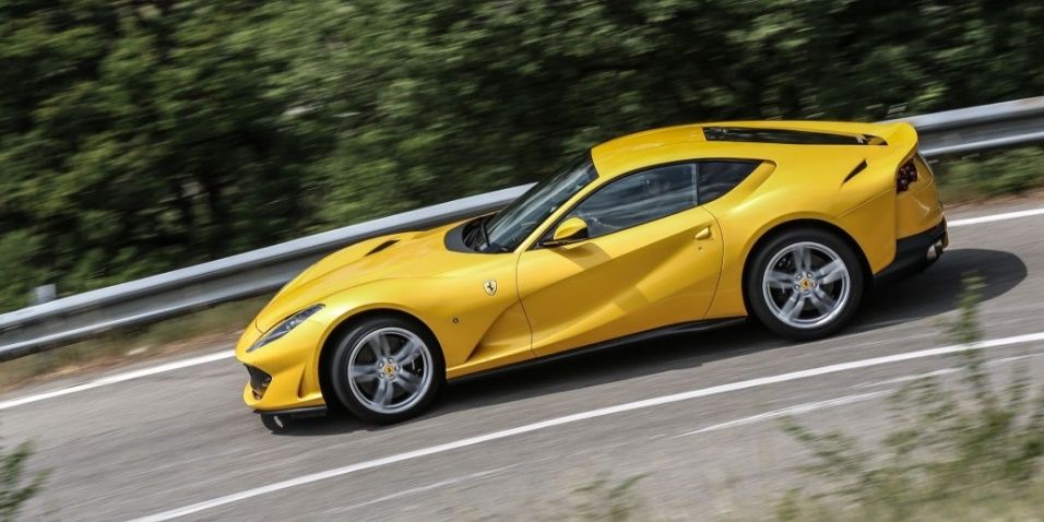 ferrari 812 superfast amarillo visto de perfil en una carretera de montaña