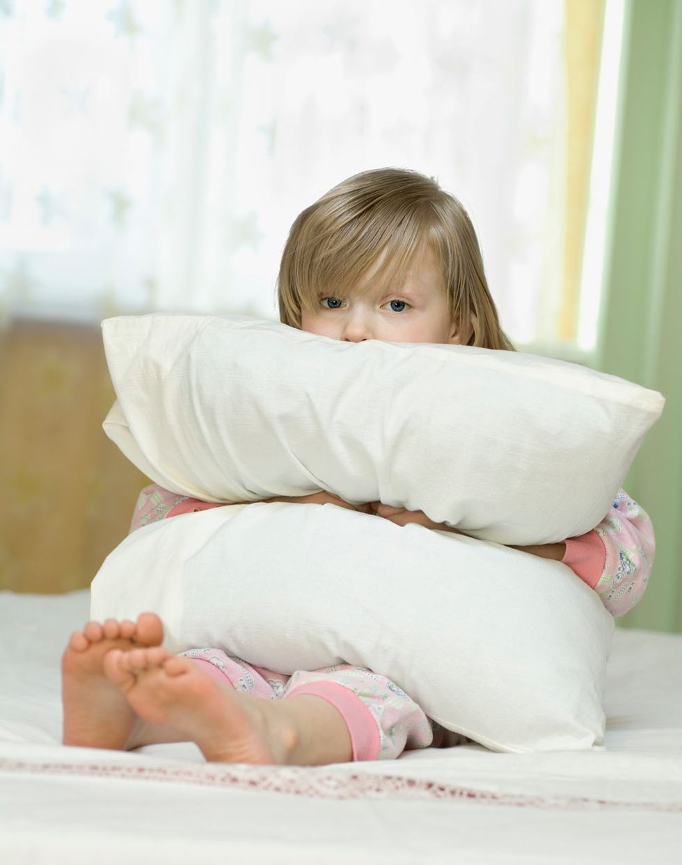 una niña a la que le cuesta conciliar el sueño abraza una almohada