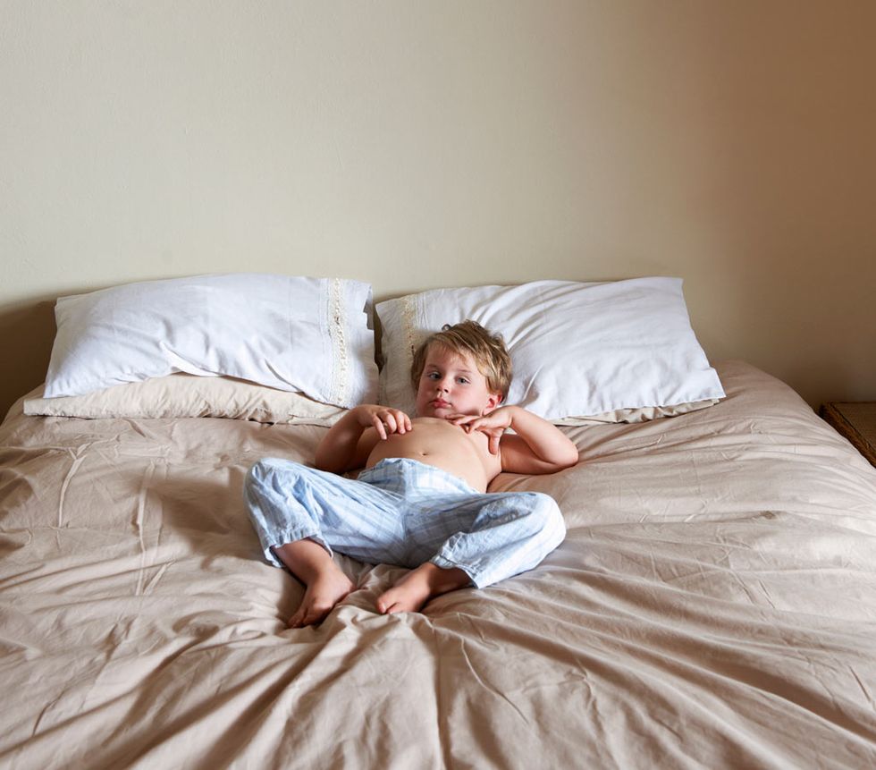 soluciones a distintos problemas de sueño infantil como son las pesadillas en los niños más pequeños, como el de la foto que aparece tumbado en la cama sin la parte de arriba del pijama