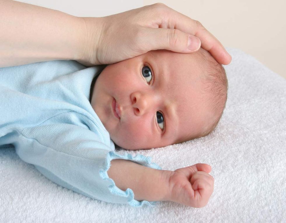 un color amarillento en la piel del recién nacido, como el que aparece despierto y con el brazo subido en la foto, puede deberse a la ictericia
