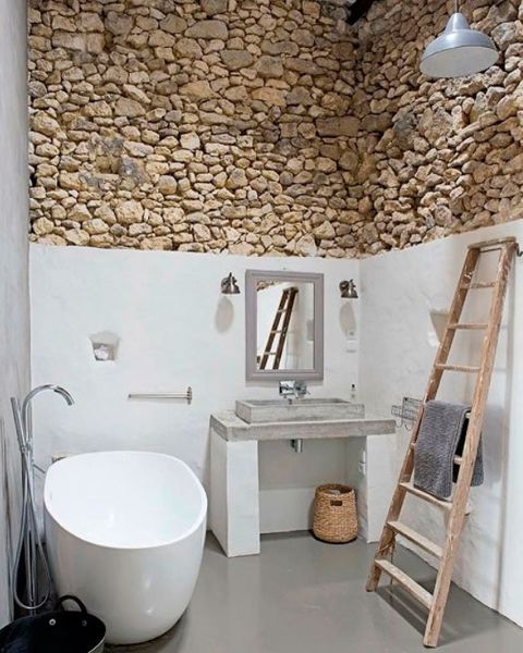 baño rústico con paredes de piedra