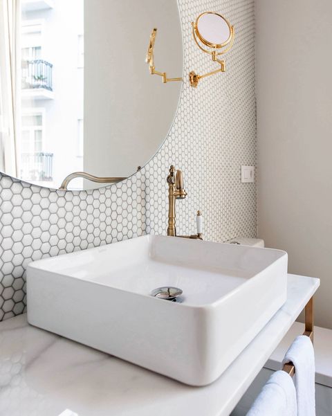 baño blanco con teselas y detalles en dorado