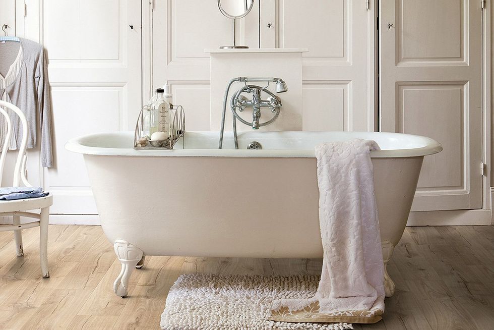 baño con bañera exenta vintage y suelo de madera