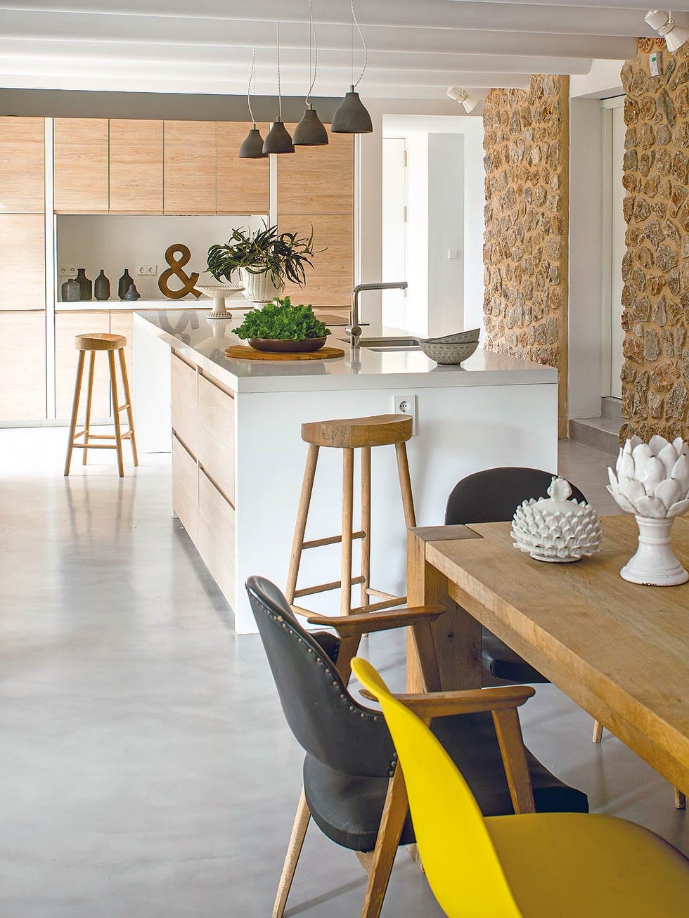 comedor con pared de piedra y sillas vintage