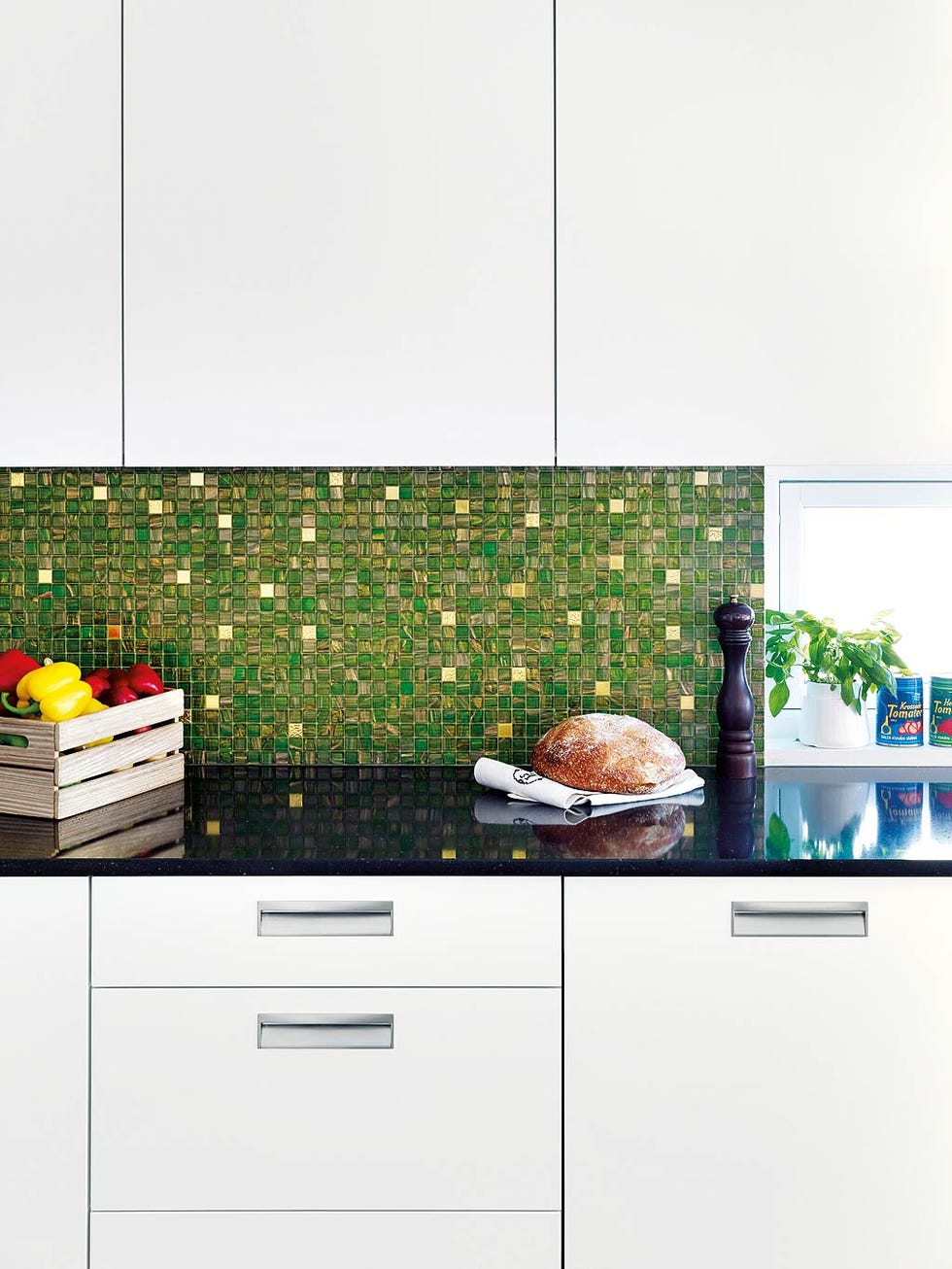 Cocina con encimera negra y fondo de gresite verde