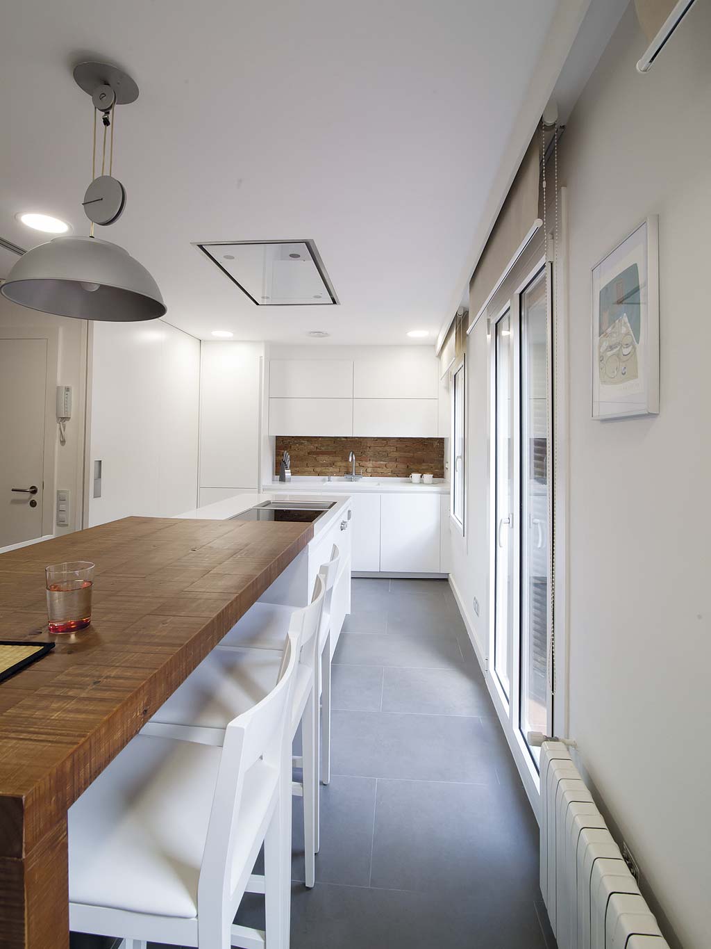 cocina abierta con isla alargada y encimera de madera