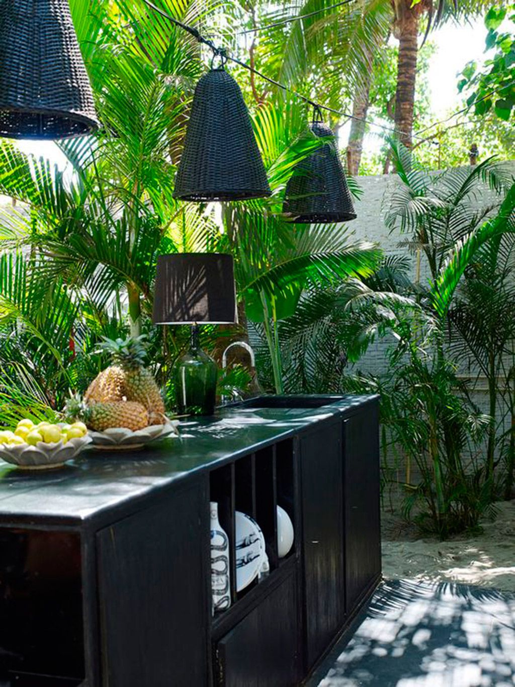 cocina exterior en el jardín con  muebles en negro