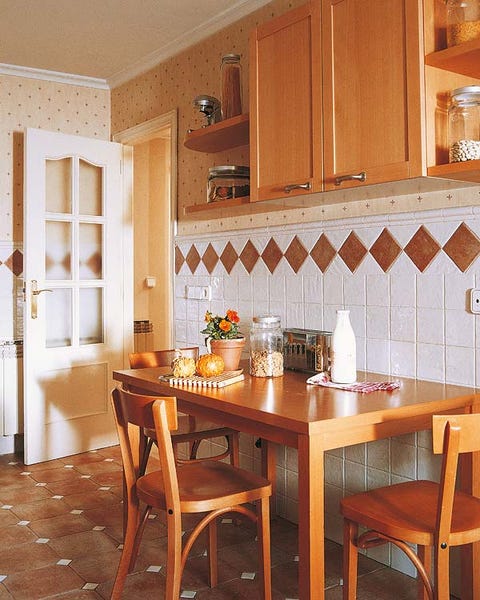 Una cocina con muebles blancos y de madera