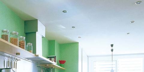 una cocina con península y office en verde y blanco