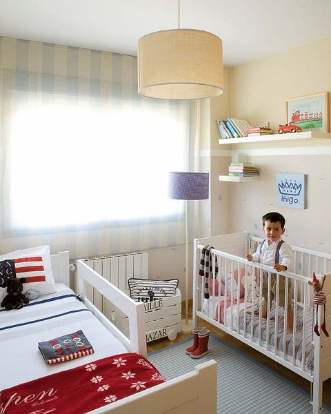 Un dormitorio con cama y cuna