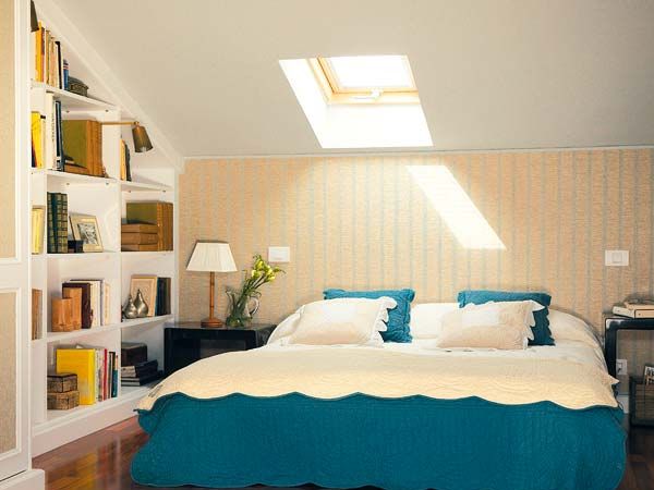 Par de camas supletorias en habitación abuhardillada con techo