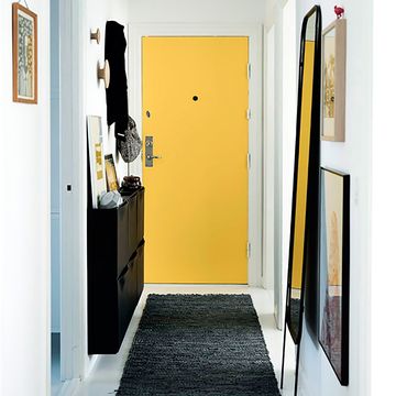 pasillo en amarillo y negro con zapatero y espejo