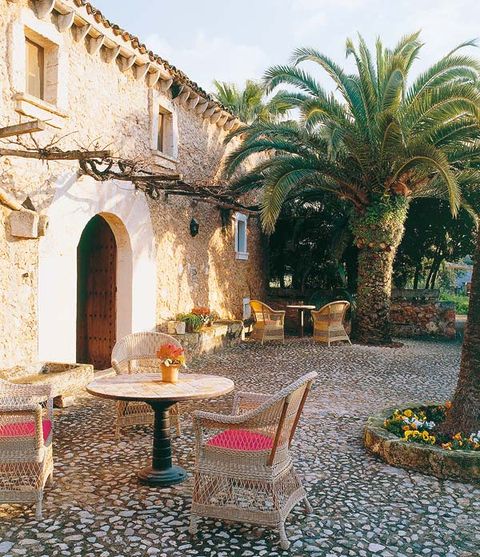 Table, Furniture, Arch, Arecales, Hacienda, Outdoor table, Palm tree, Coffee table, Courtyard, Outdoor furniture, 