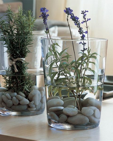 arreglo floral en vasija de cristal con lavandas y piedras,