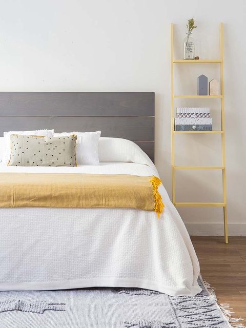 Dormitorio con escalera decorativa amarilla como mesilla