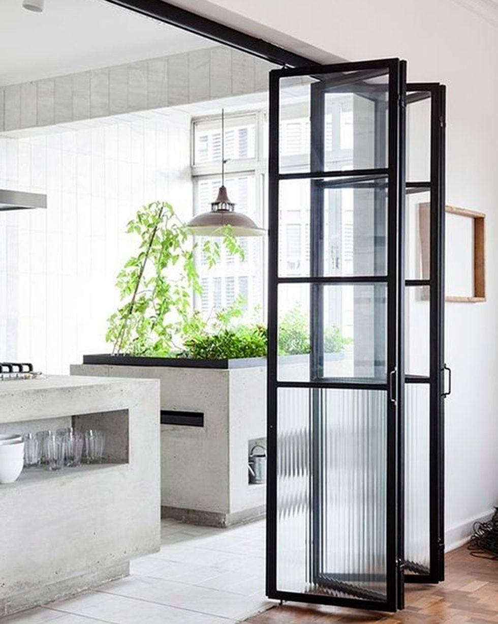 cerramiento de cristal para separar la cocina de estilo industrial con puertas plegables correderas