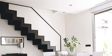 comedor blanco con escalera en negro