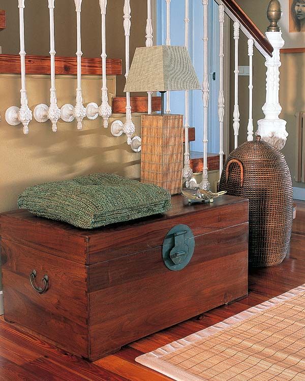 Un baúl en la entrada de esta casa sustituye a la típica consola de  recibidor y sirve como mueble de almacenaje.