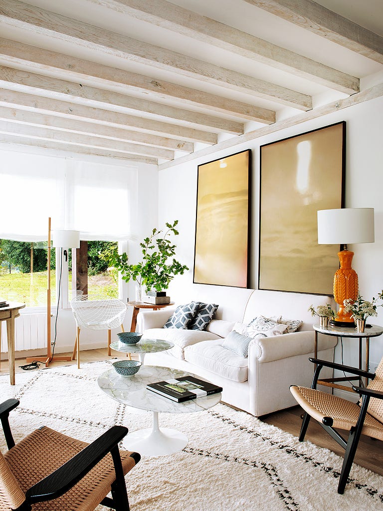 salón luminoso con sofá blanco y butacas de fibra