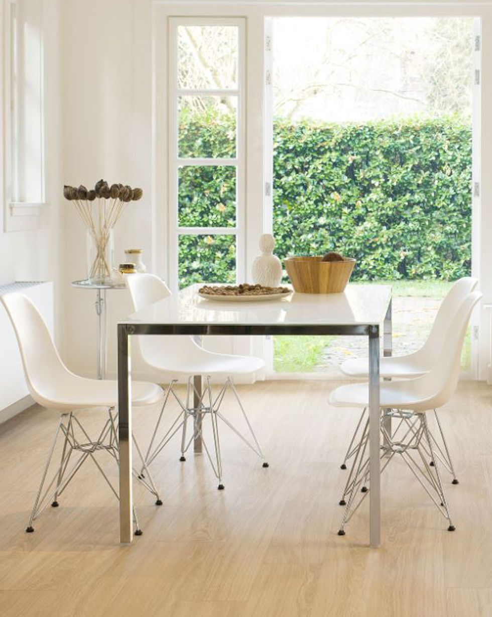 dining room with glass and metal table and white chairs
