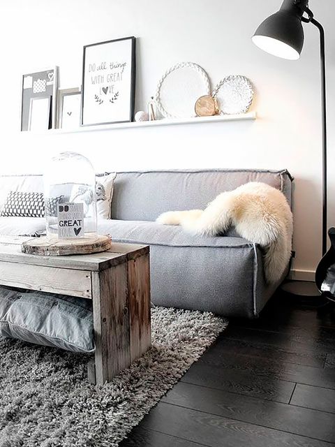 salón blanco con sofá cómodo gris y manta de pelo