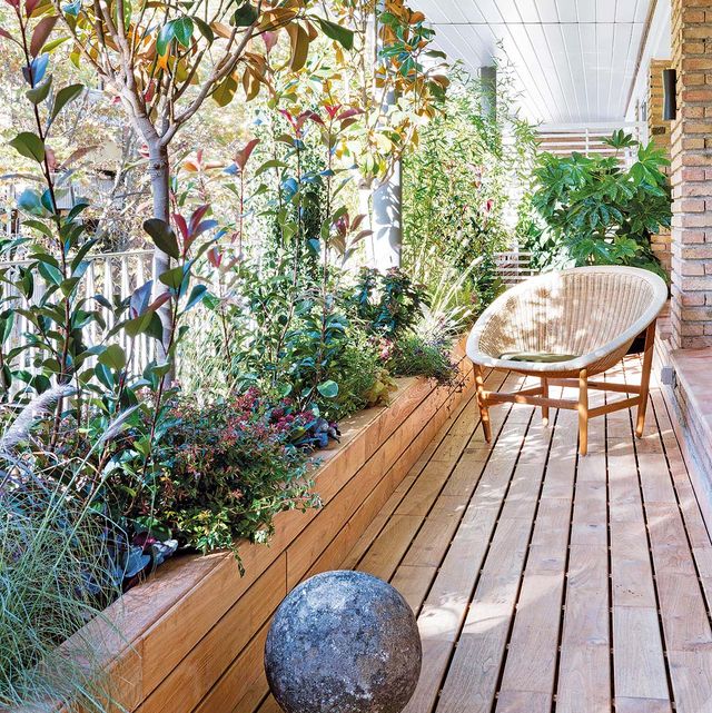 terraza con jardineras llenas de plantas y suelo de madera