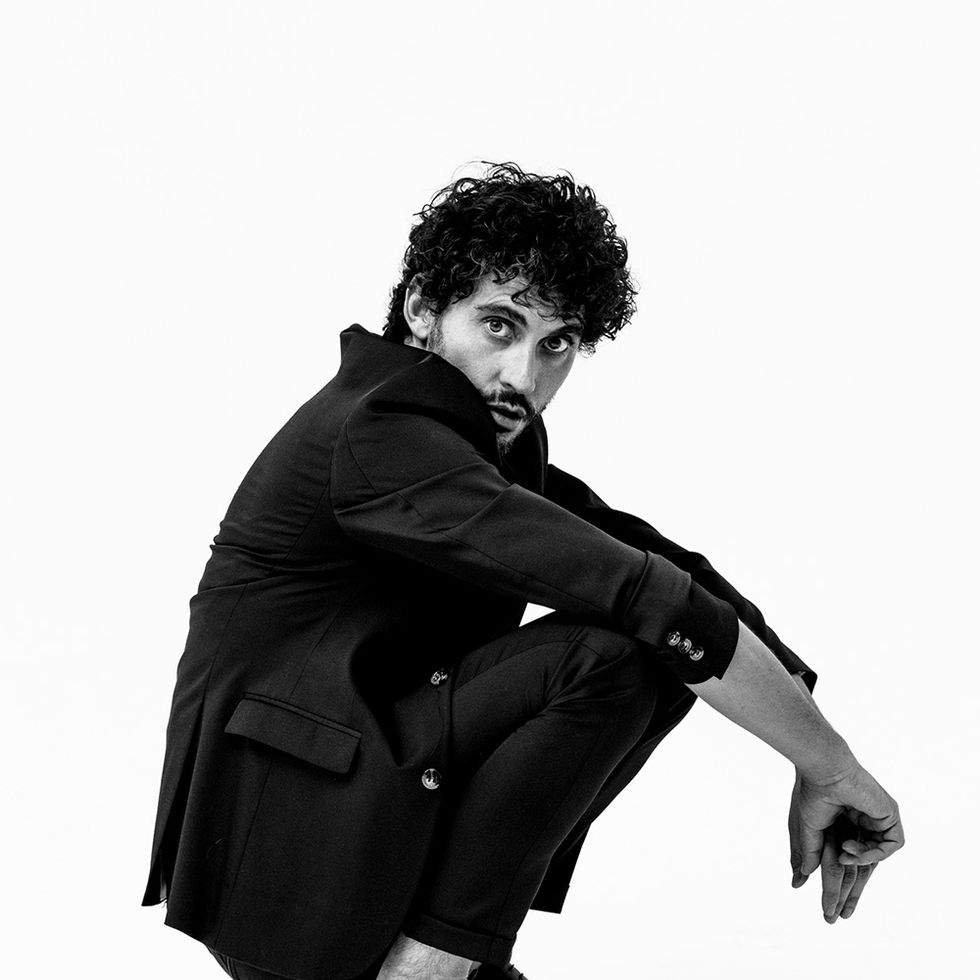 Black, Sitting, Hairstyle, Footwear, Black-and-white, Joint, Photography, Leg, Photo shoot, Black hair, 