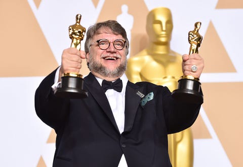 Award, Finger, Tuxedo, Gesture, Thumb, Formal wear, Award ceremony, Suit, Fictional character, Metal, 