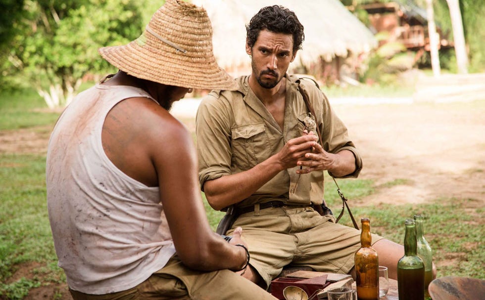Human, Human body, Hat, Mammal, Drink, Bottle, Sun hat, Sitting, Facial hair, Luggage and bags, 