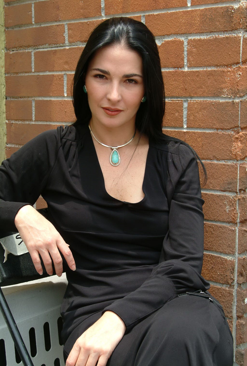 Jewellery, Sitting, Shoulder, Hand, Brick, Dress, Fashion accessory, Necklace, Brickwork, Black hair, 