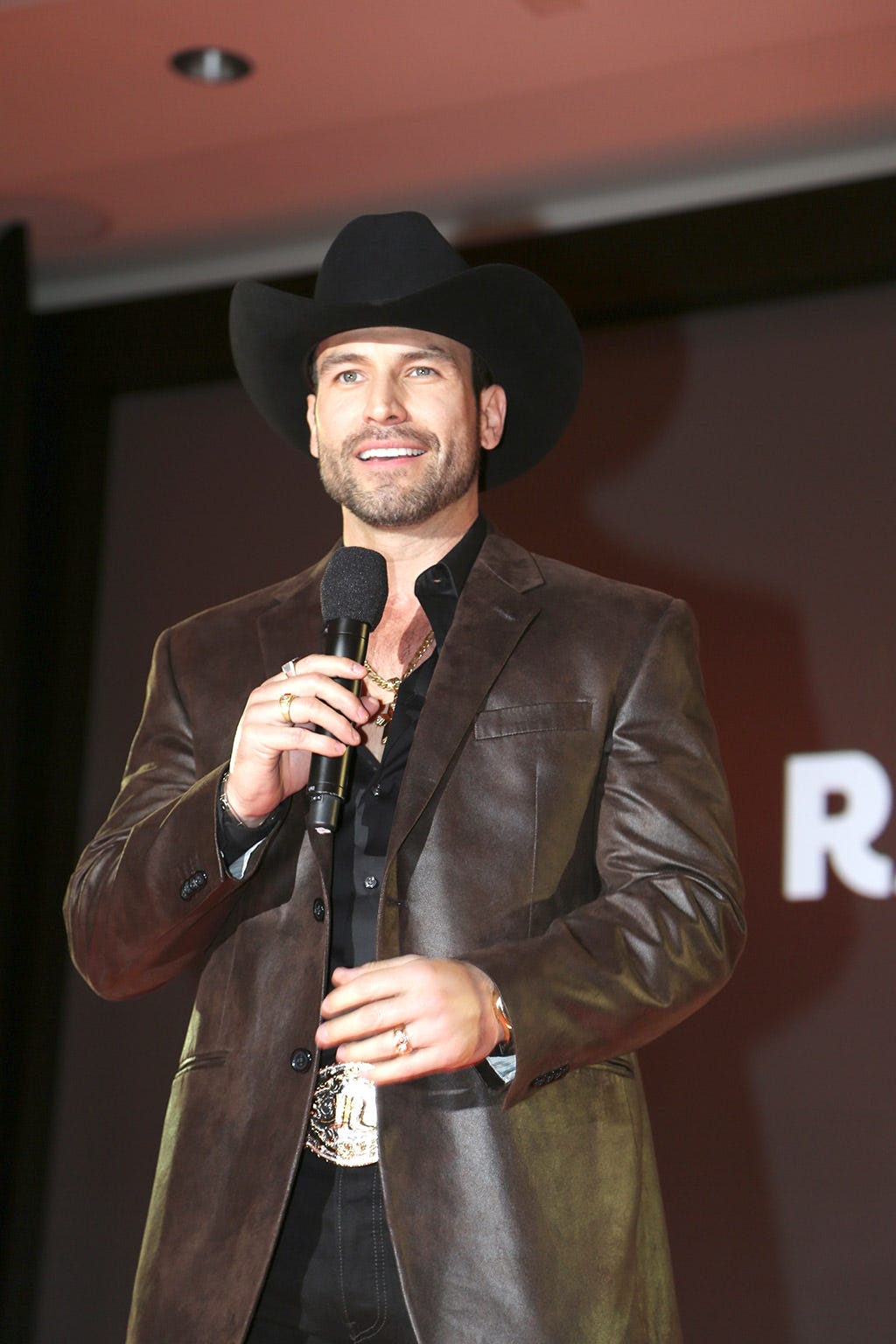 Clothing, Microphone, Audio equipment, Hat, Coat, Dress shirt, Shirt, Hand, Outerwear, Standing, 