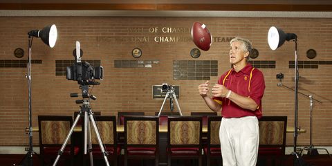 usc football coach pete carroll tossing football in heritage hall