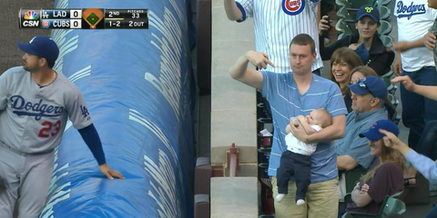 Dad catches foul ball at Cubs while holding baby.