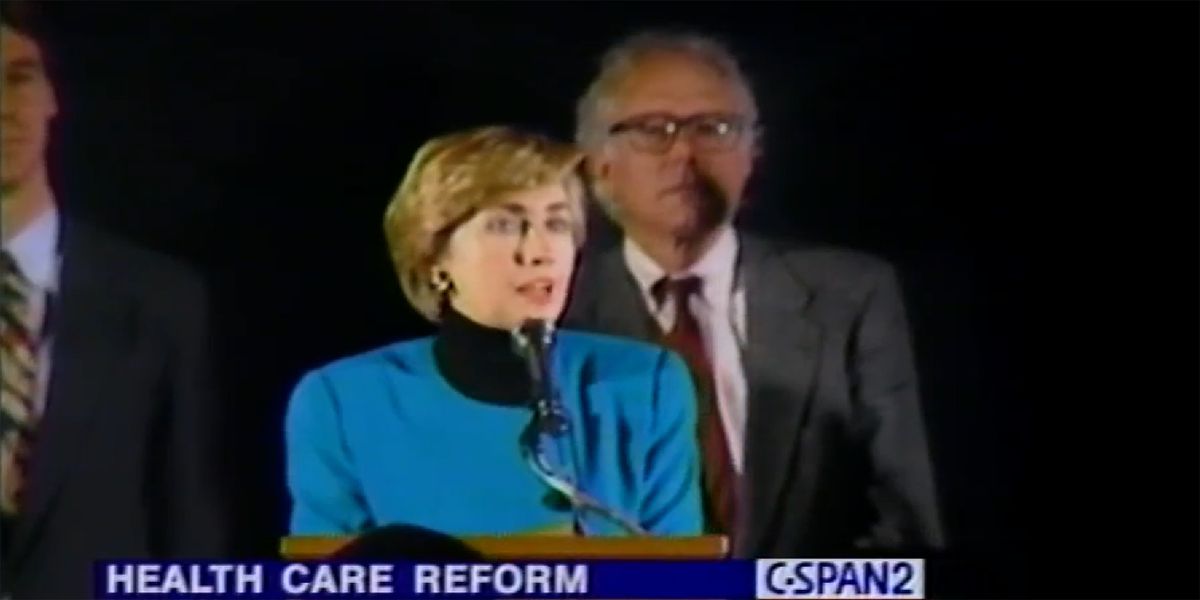 still image of hillary clinton delivering a speech in 1993. bernie sanders stands behind her. a banner at the bottom of the image reads "health care reform"