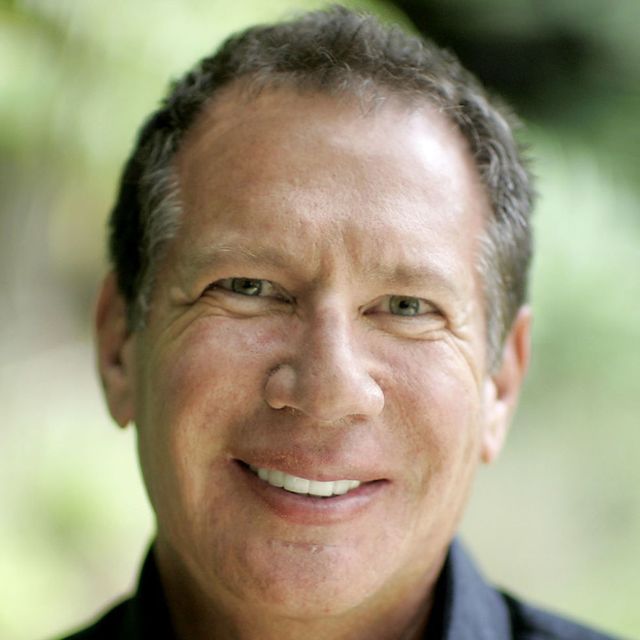 a headshot of Garry Shandling smiling against a green background